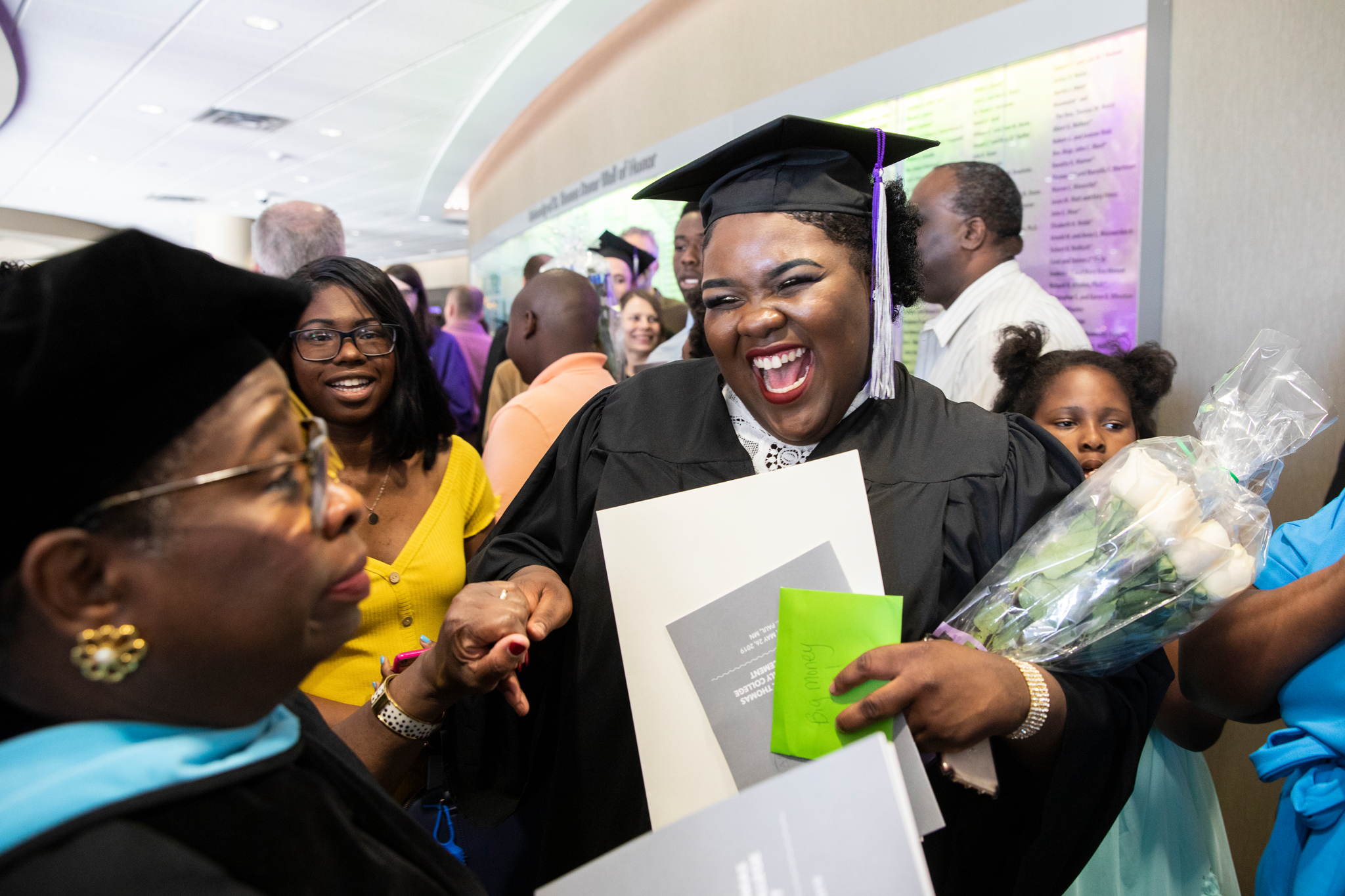 a student celebrates with a professor after commencement in the Anderson Student Center