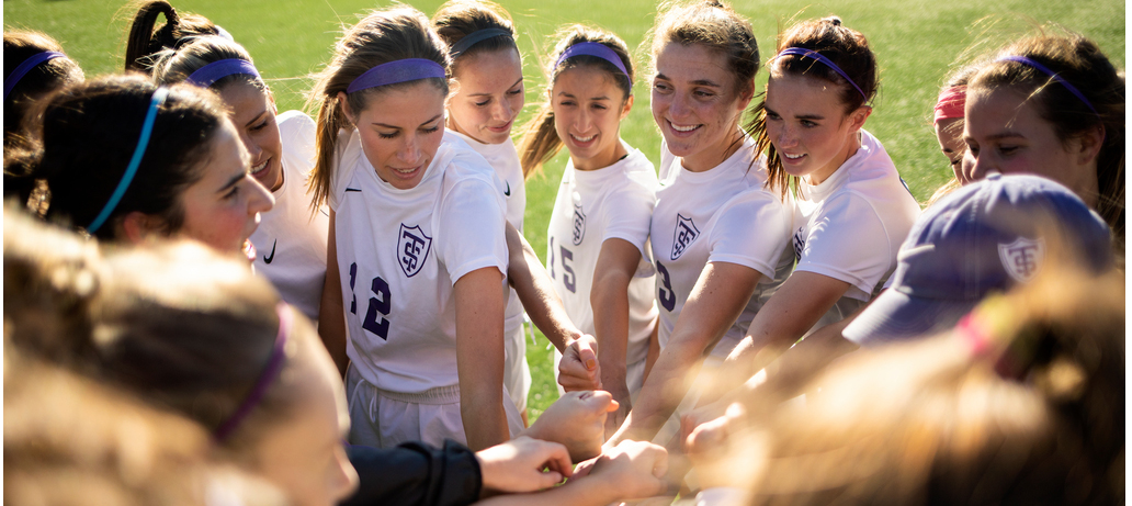 The women's soccer team works together toward a win.