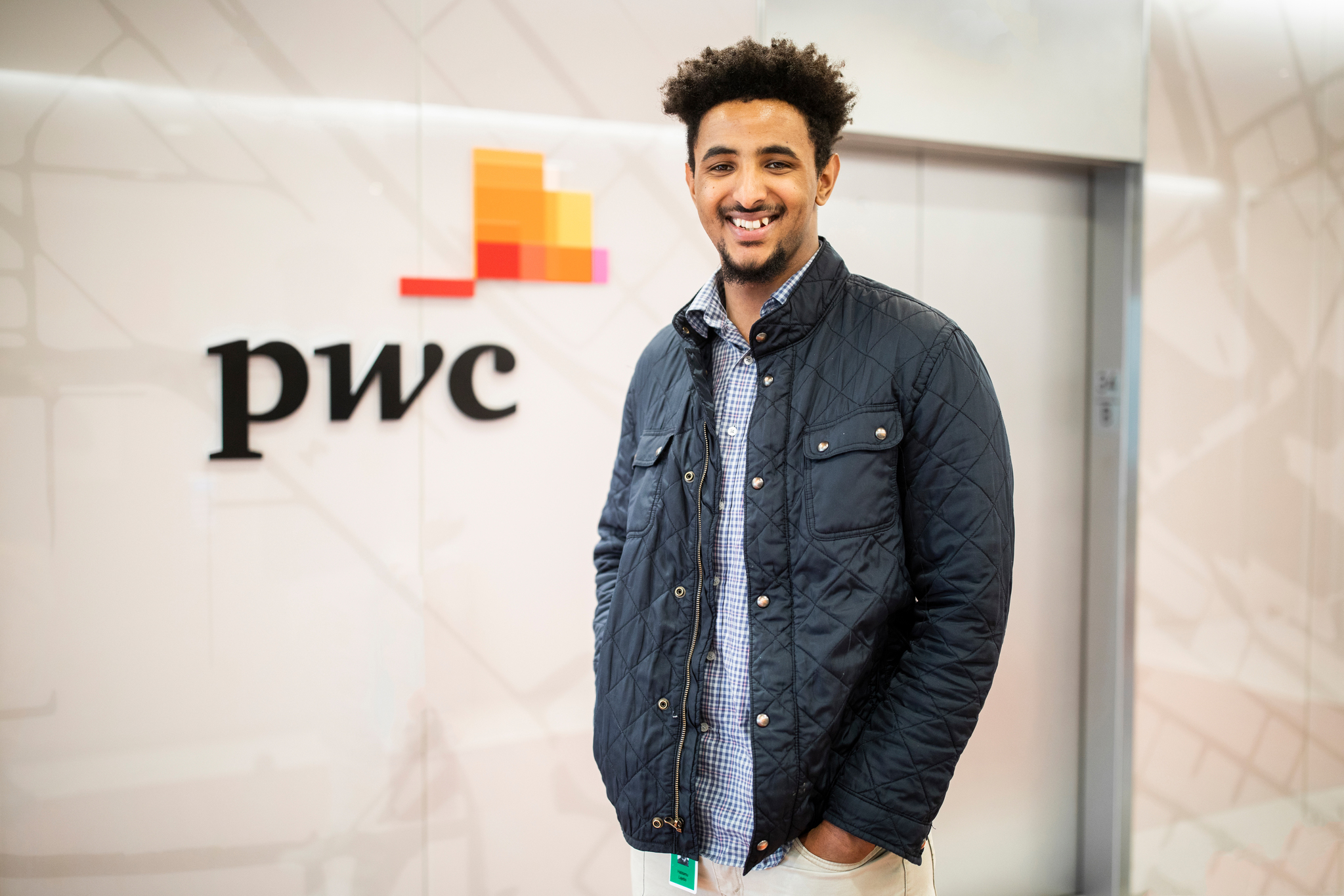 a DFC student poses for a picture at a price-waterhouse-cooper office