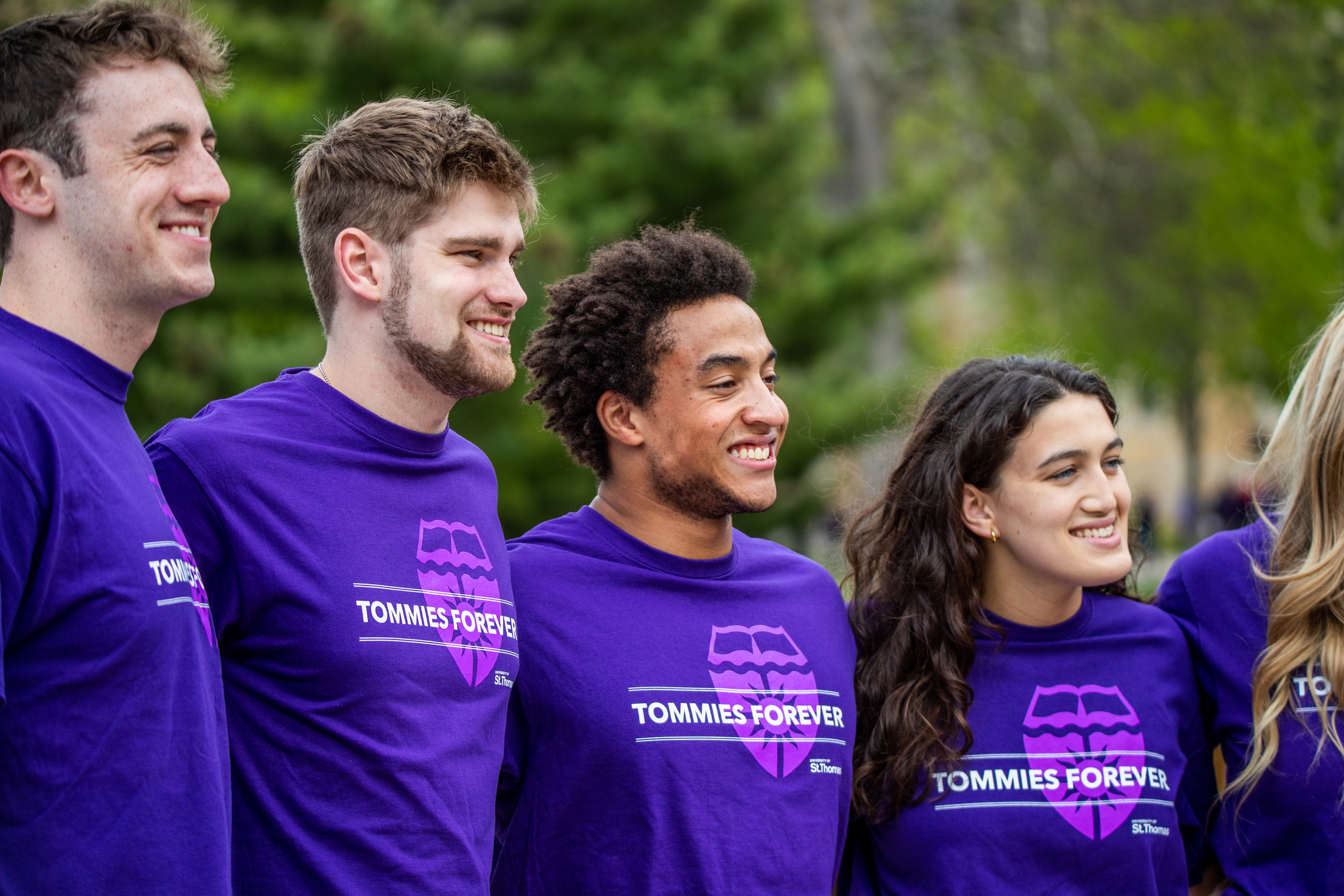 four students in purple St. Thomas t-shirts