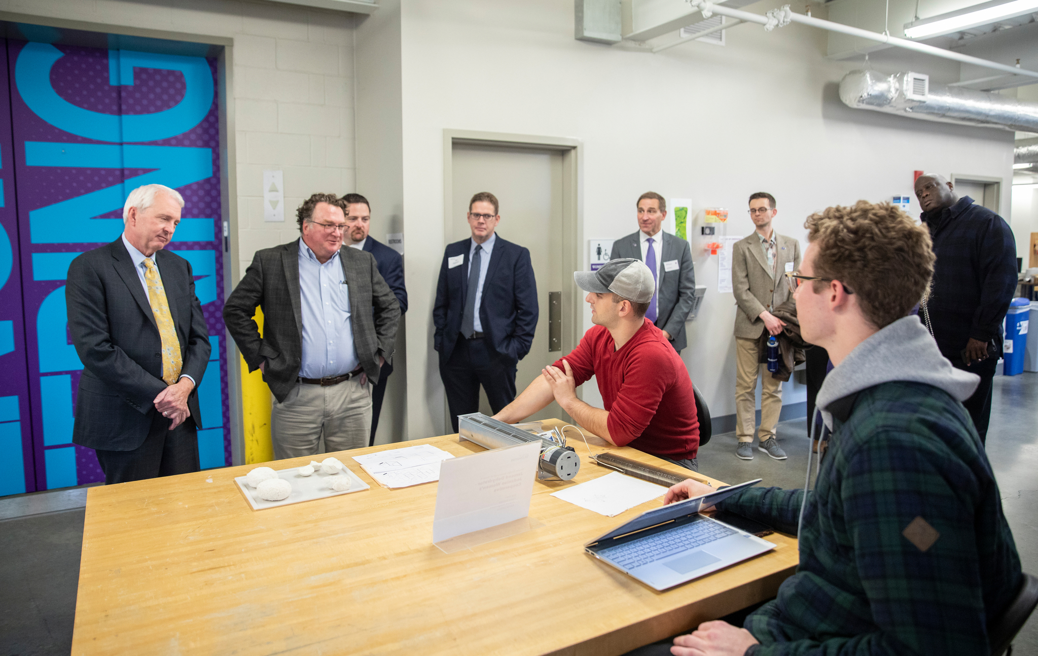 Xcel Energy CEO Ben Fowke and Engineering Dean Don Weinkauf listen as students discuss their senior design project during a tour of the School of Engineering’s microgrid solar panel array in the Facilities and Design Center in St. Paul on November 1, 2019. 