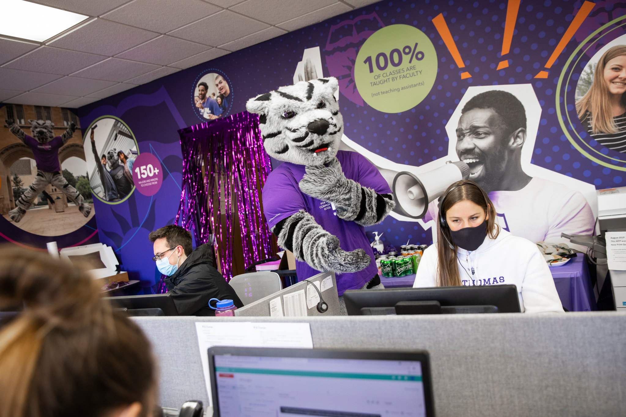 Tommie interacts with student employees of the Engagement Center