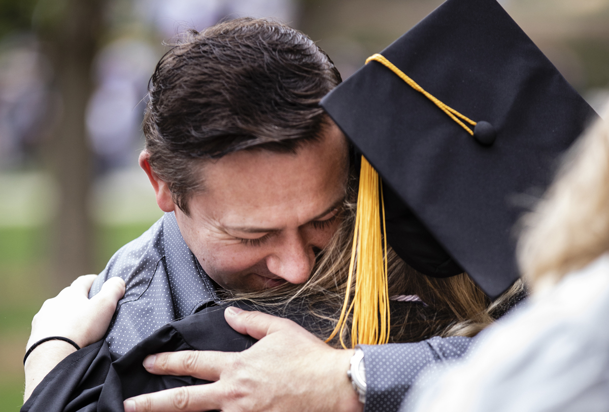 a father and daughter embrace at commencement
