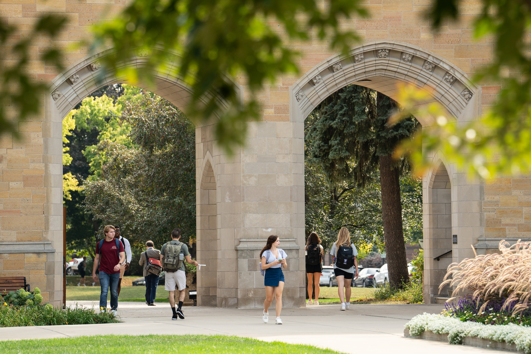 Students walk through the Arches on a nice fall day