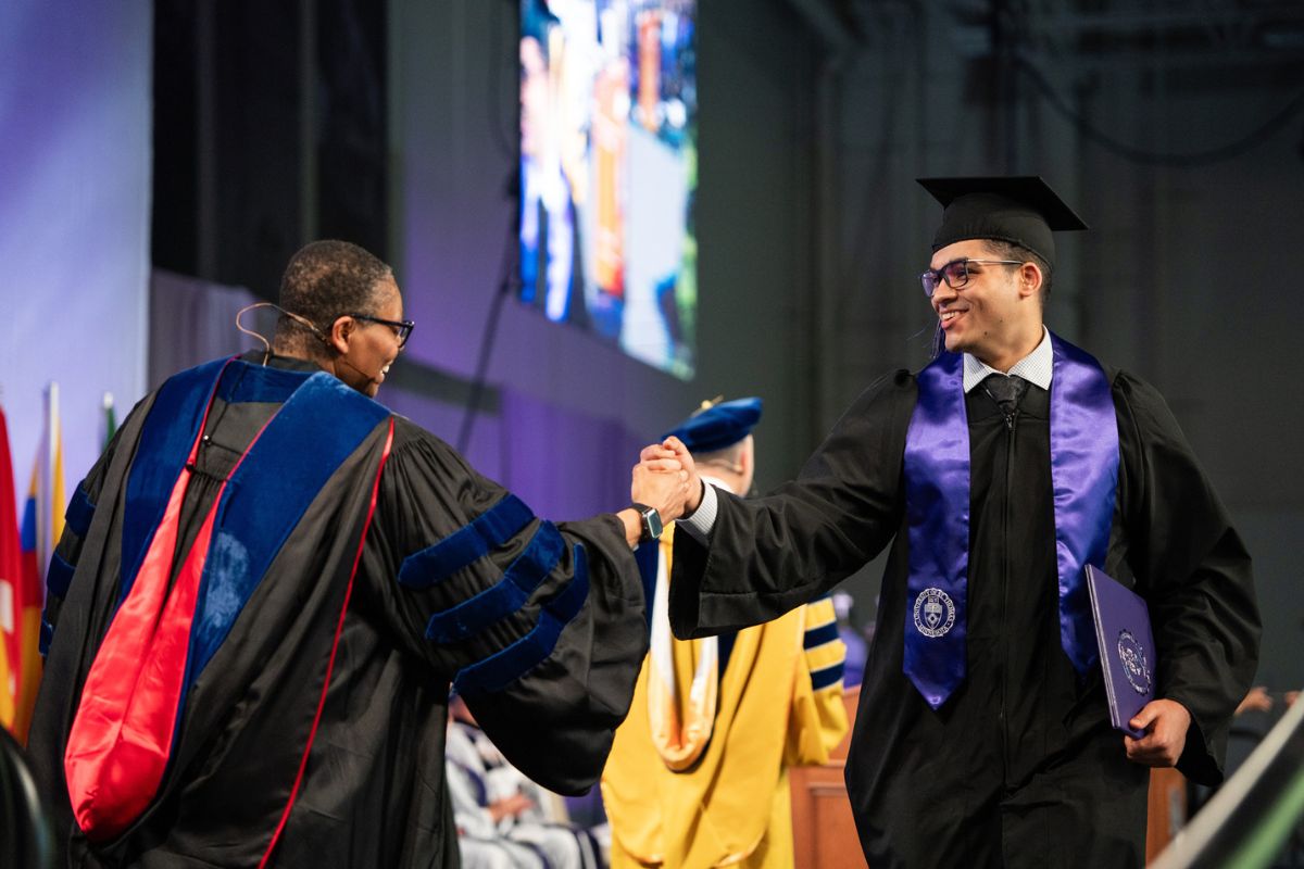 Dean Buffy Smith greets a student at the Commencement Ceremony for DFC