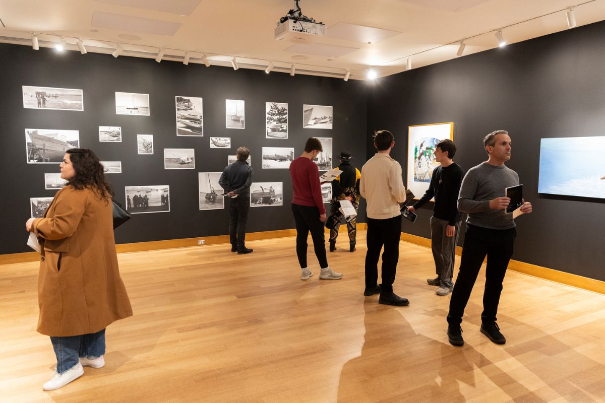People look at art during an opening reception in the Monahan Gallery in the Schoenecker Center