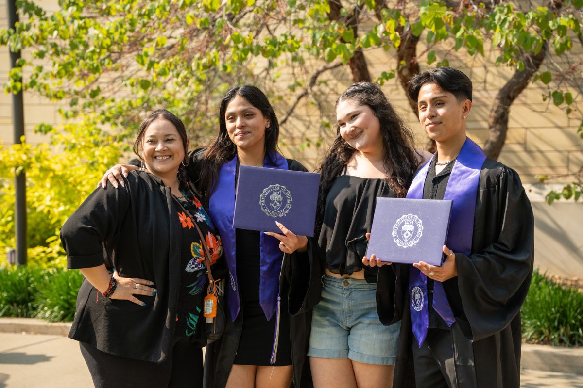 DFC Students hold diplomas with friends and family