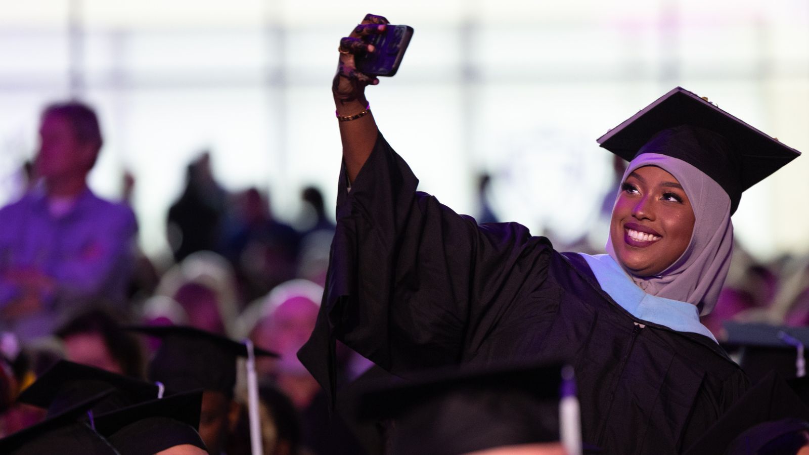 A student takes a selfie during the Graduate Commencement Ceremony