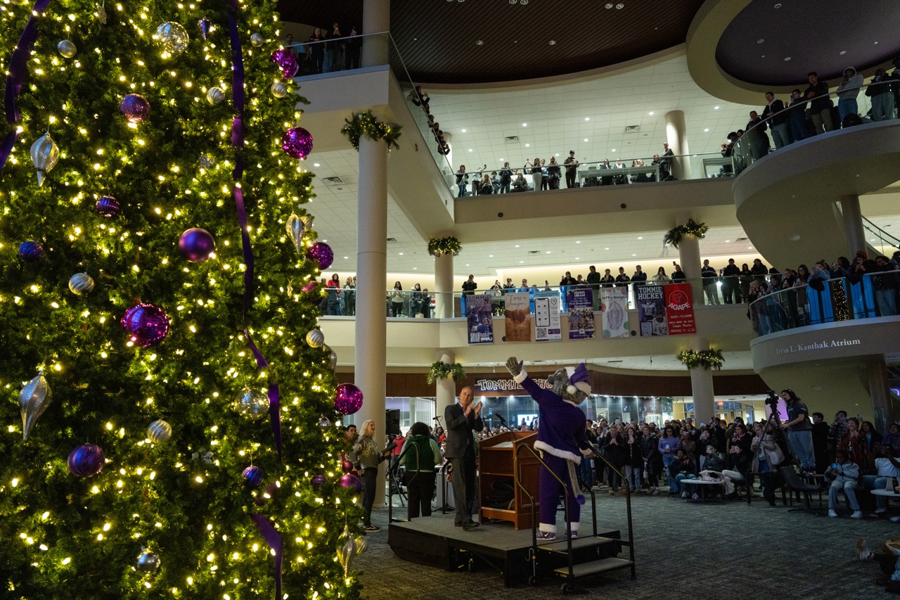 The Anderson Student Center tree lighting - all three floors are visible and filled with people, and the lit Christmas tree is in the foreground