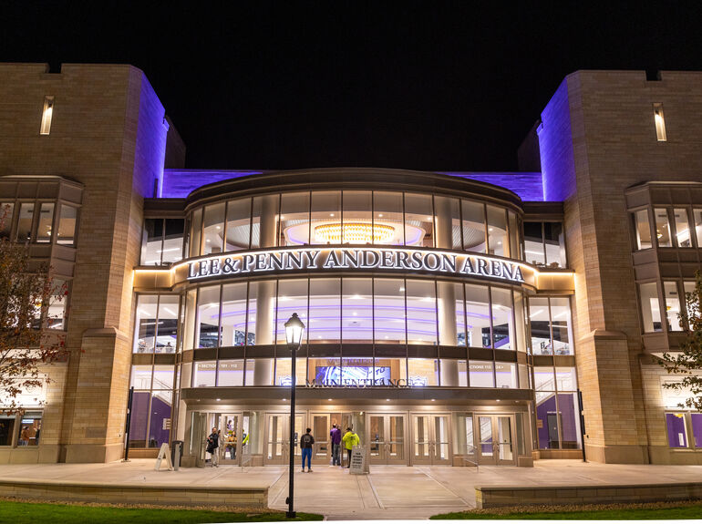 A nighttime view of the Lee & Penny Anderson Arena lit up at night