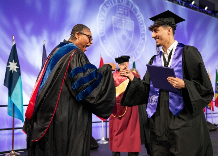 Dean Buffy Smith shakes a DFC graduate's hand as he crosses the stage at commencement