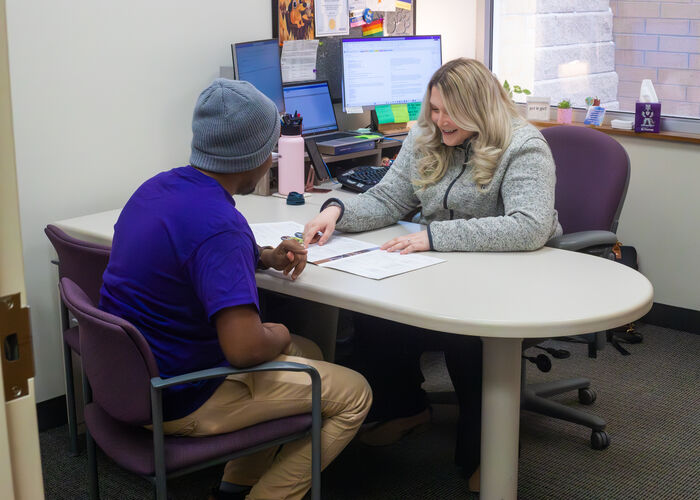 A student meets one-on-one with a St. Thomas staff member in a campus office to review information and discuss available support