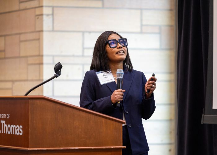 A student in a blue suit presents at a podium