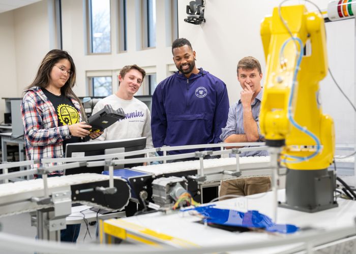 Students look at a machine in a robotics lab