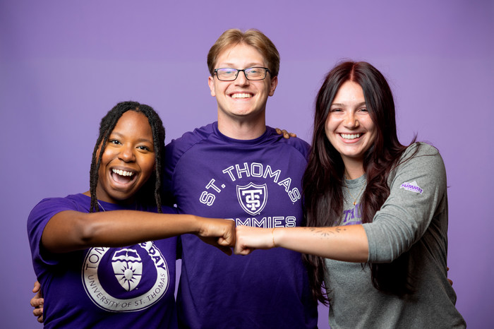 3 students smiling while wearing Tommie give day shirts