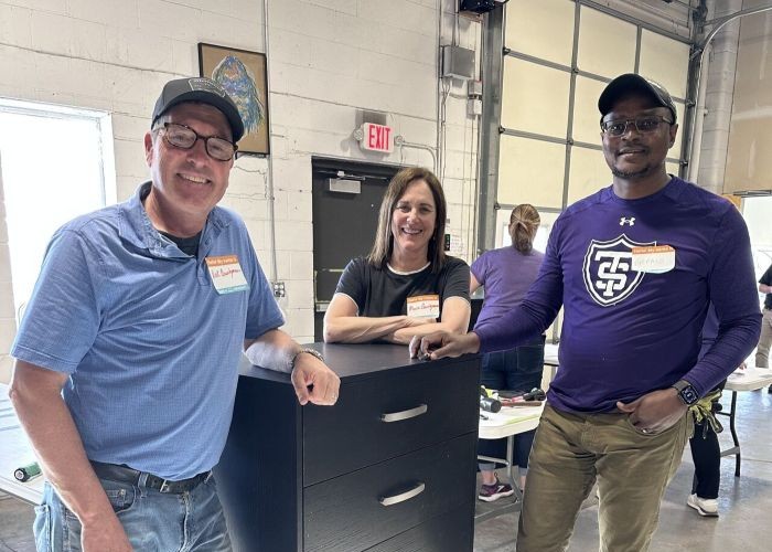Alumni volunteers build dressers at Bridging