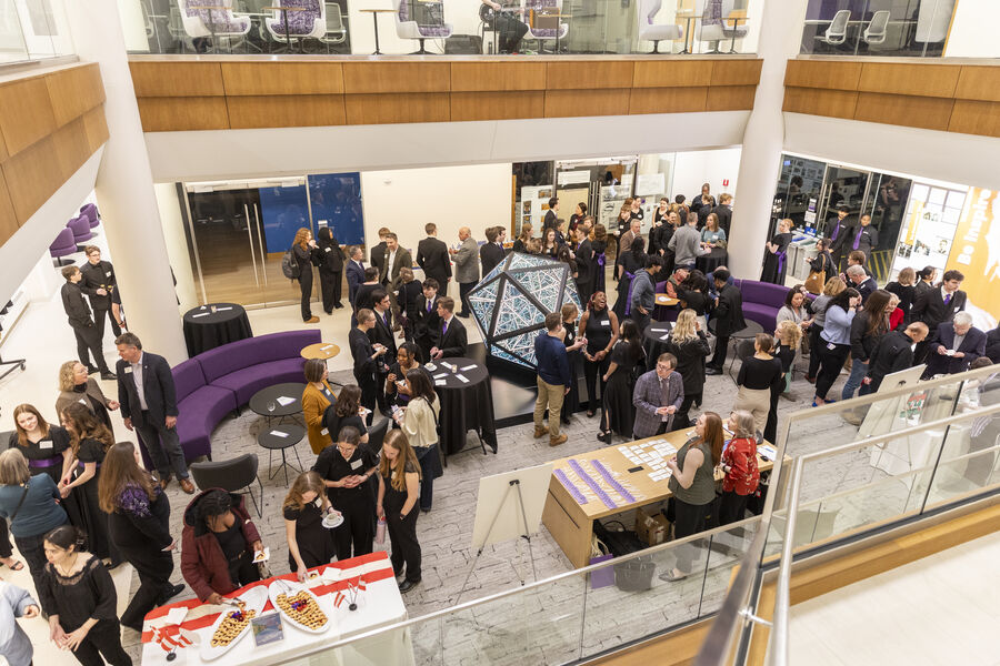 People toast at an event in the Schoenecker Center