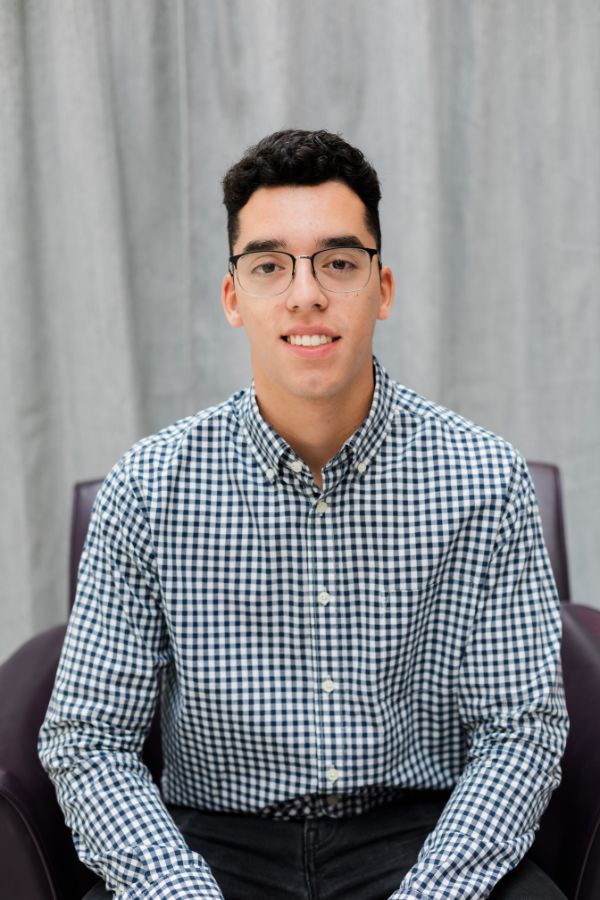 Professional photo of Leo Jimenez, seated in a chair 