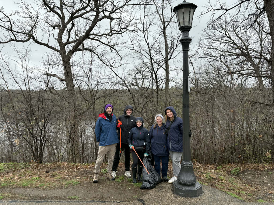 A group of Tommies volunteering by cleaning up the river walk together