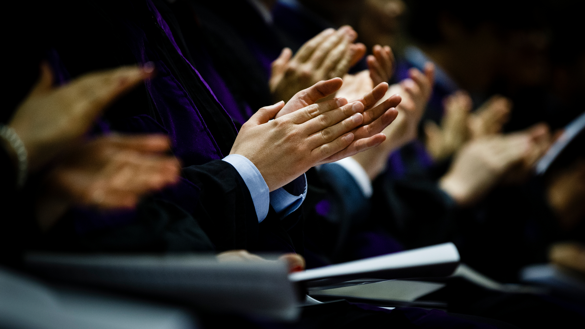 People clapping during a speech at a ceremony