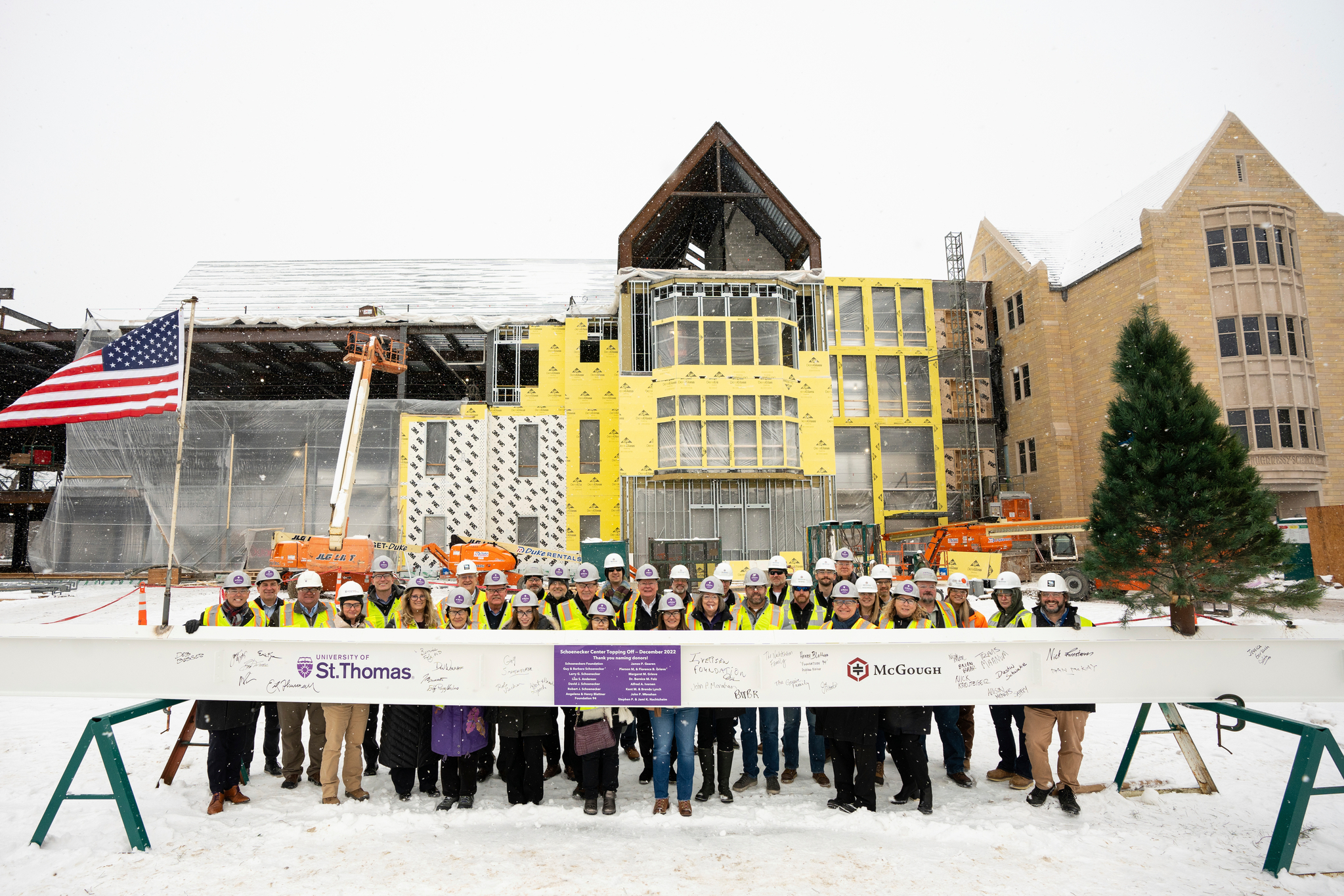 Donors, construction personnel, and St. Thomas staff pose for a group photo during a beam signing ceremony celebrating the completion of the structural stage of the building of the Schoenecker Center STEAM complex