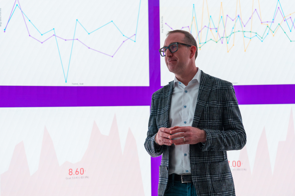 A male professor wearing a sport coat stands in front of a large screen in the Data Visualization Lab in O’Shaughnessy Science Center.